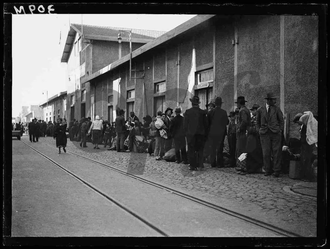 Emigrantes aguardando embarque junto ao armazém do porto